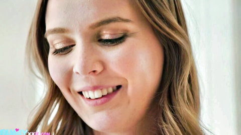 Closeup of smiling young blonde babe with glossy lips and long wavy hair