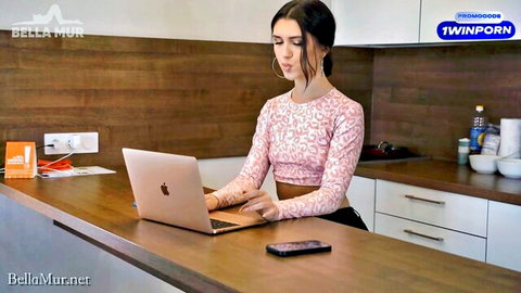 Bella Mur in pink patterned top typing on laptop, slim brunette tease