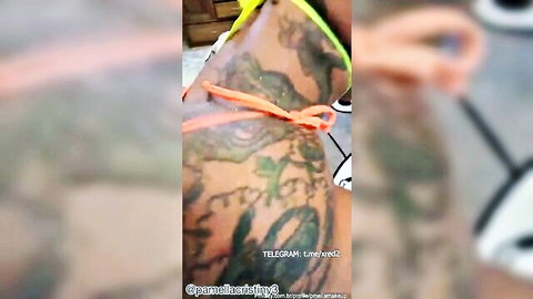 Tattooed ebony woman in skimpy orange bikini, side pose tease