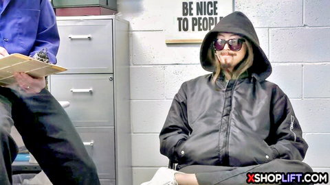 Hooded brunette teen shoplifter confronted by security guard in office with be nice sign