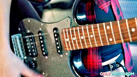 Luna Bunny playing silver guitar in plaid shirt and pink outfit