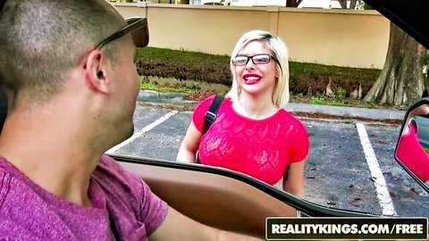Blonde MILF in red top smiling at guy picking her up in car