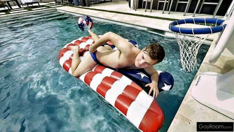 Muscular white guy in American flag speedo lounges on pool float for 4th of July gay party