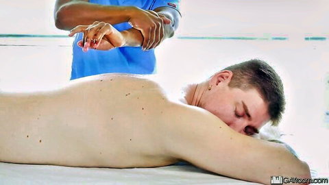 Erotic gay massage with nude white guy on table, black masseur in scrubs