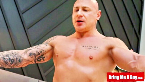 Bald muscular man with arm tattoos posing shirtless in hot selfie