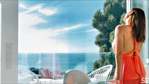 Antonia Sainz in sexy red backless dress on balcony overlooking sea