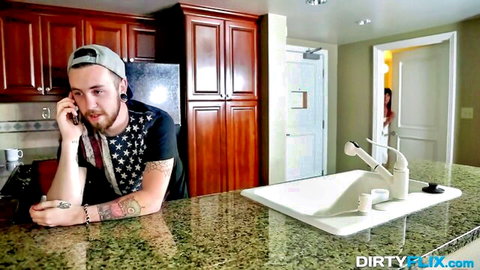 Tattooed bearded guy on phone, trans woman peeks from doorway