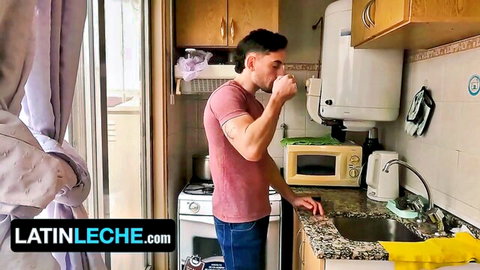 Handsome Latino guy in red shirt drinking from white mug in kitchen