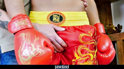 Handsome young jock in red dragon boxing trunks touched by partner in trans scene
