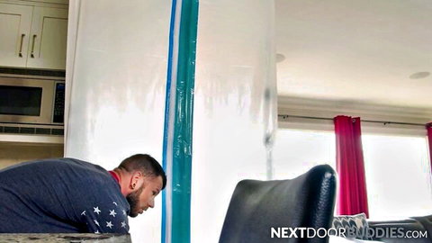 Athletic gay hunk bent over on knees in kitchen near blue tarp