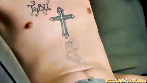 Tattooed young man's shirtless chest with cross and stylized ink tattoos teasing abs and pubes