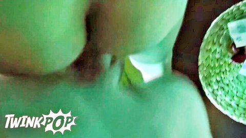 Blurry green-tinted closeup of smooth twink ass cheeks with TwinkPop watermark