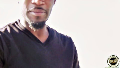 Close-up of handsome black man with goatee and serious expression in dark V-neck shirt