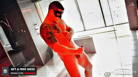 Muscular tattooed hunk in black mask strokes massive hard cock in steamy shower