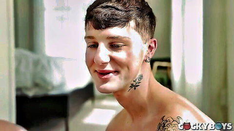 Colton Spence shirtless with tattoos, smiling in intimate gay scene