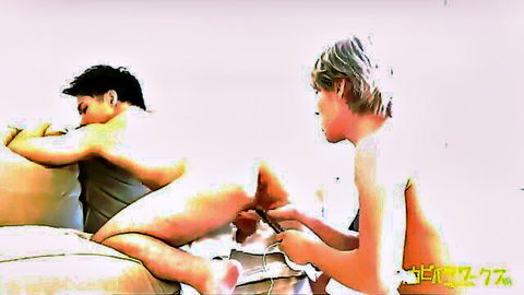 Japanese twink spreads legs exposing cock and ass while another boy fingers his hole on couch
