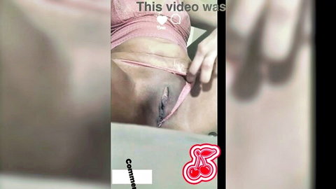 Close-up of woman in pink lingerie with hand touching exposed pussy intimately