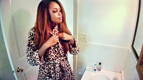 Sexy ebony woman in leopard print robe teasing untying in bathroom mirror