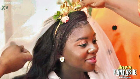 Ebony bride in white veil and floral crown during African wedding ceremony