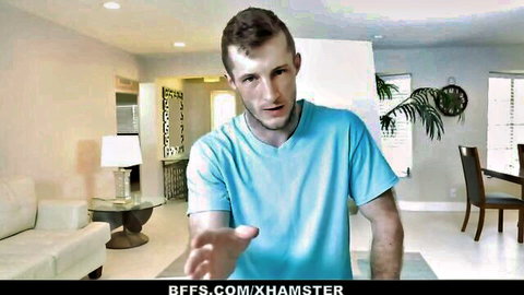 Athletic man in light blue t-shirt extends hand invitingly in modern living room
