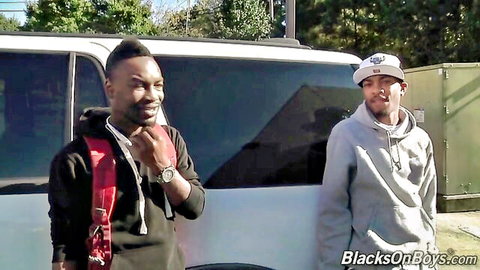 Two handsome black men in hoodies smiling by white van on BlacksOnBoys