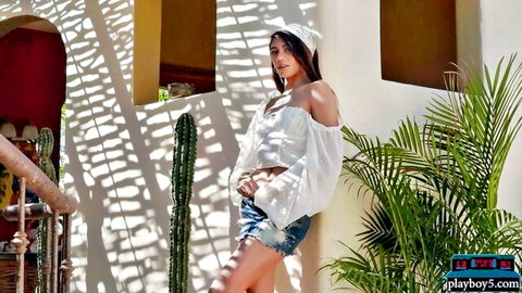 Sexy Asian babe teasing in tiny denim shorts and off-shoulder crop top outdoors by cactus