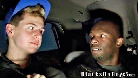 Blonde white twink in blue cap stares intently at handsome black stud in dark van