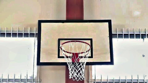 Indoor basketball hoop in school gym, empty backboard and rim