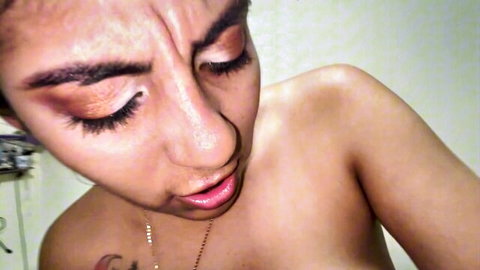 Busty Latina woman with sultry gaze and glossy lips in topless pose