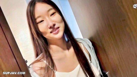 Young Asian woman in white tank top and cardigan, smiling with long hair