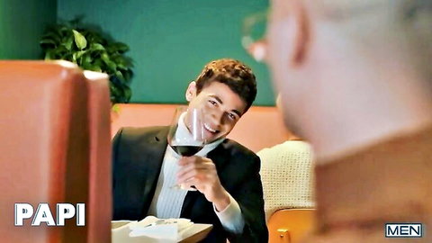 Clark Delgaty in suit sipping wine, smiling seductively in gay bar scene