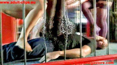 Femdom trample scene with women in stockings dominating caged man
