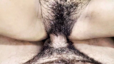 Close-up of woman's thick bushy pubic hair covering hairy pussy lips