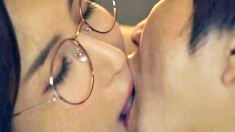 Japanese tutor in glasses intimately kissing man close-up