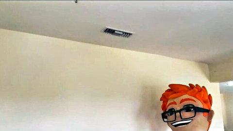 Smiling cartoon redhead mascot head with glasses against plain white wall
