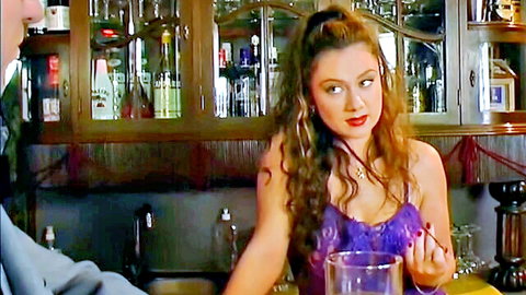 Curvy brunette in purple lace lingerie holding a drink seductively