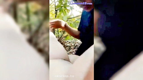 Southeast Asian woman in white outfit teased by man's hand between legs outdoors