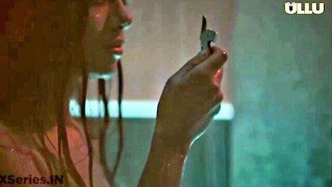 Intense Indian woman with long hair holding knife in steamy profile view from Corporate Episode 7