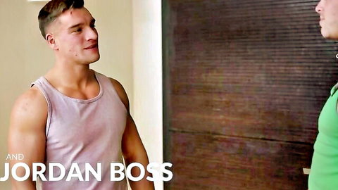 Muscular gay studs in tight tank tops stand close teasing each other