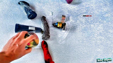 Lisa Sophie with assorted sex toys, dildos, vibrators and red stockings in explicit setup