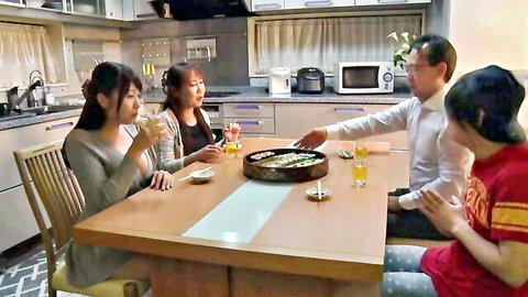 Two Japanese women dine with men at table in casual JAV scene