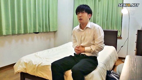 Distressed Asian man in white shirt clutching stomach on bed