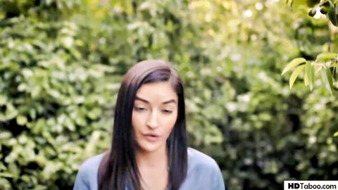 Brunette Latina woman in blue top, intense gaze outdoors in lesbian bullying thriller