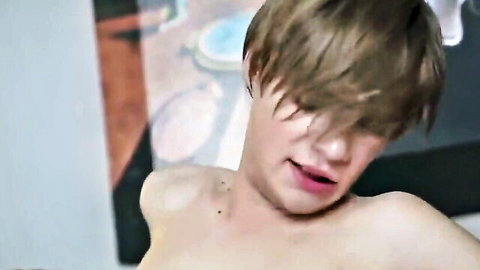 Shirtless young twink with brown hair and piercings in intense expression