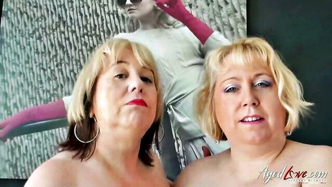 Two mature blonde lesbians posing nude, embracing topless