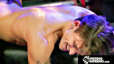Muscular hunk in intense fisting scene, smiling during erotic act