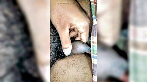 Naked young man gripping his erect penis with hand close-up solo touch