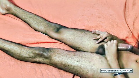 Hairy skinny gay dude spreads legs and fucks his tight asshole with thick brown dildo on bed.