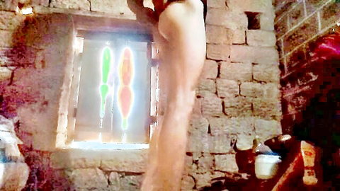 Nude pale thigh and ass cheek posed against ancient stone window with glowing phallic lights