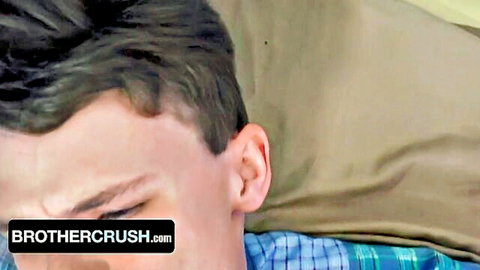 Handsome young stepbrother lying on bed with intense gaze from BrotherCrush gay porn